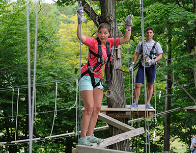 Girl and boy in aerial adventure park