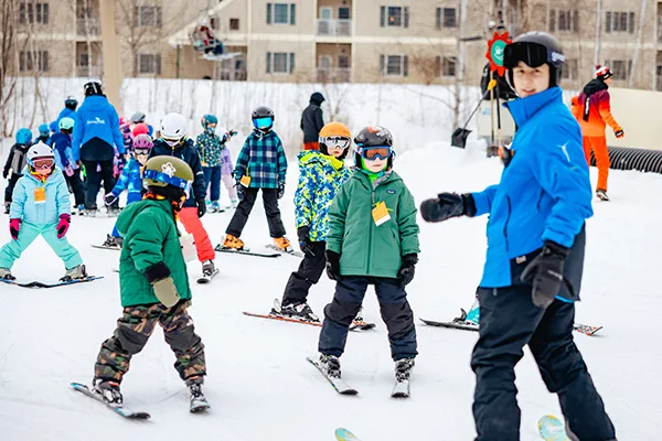 Jiminy ski instructor with group of child skiers